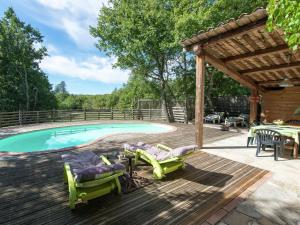 uma piscina com cadeiras e um deque de madeira com uma pérgola em Nice holiday home with pool in Ard che em Saint Alban Auriolles