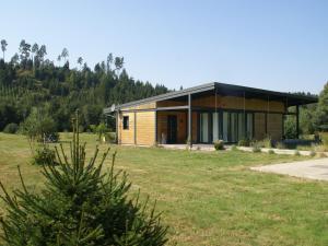 a house in a field with a tree at Comfortable apartment with balcony in Abreschviller