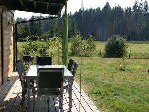 a table and chairs on a porch with a field at Comfortable apartment with balcony in Abreschviller