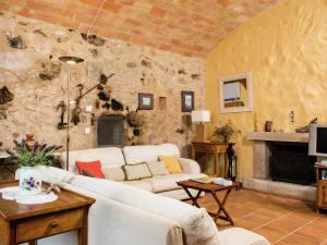 uma sala de estar com um sofá branco e uma parede de pedra em Belvilla by OYO Mas Delfi em Sant Pere Pescador