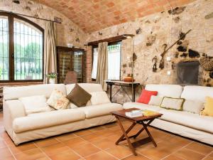 uma sala de estar com dois sofás brancos e uma parede de pedra em Belvilla by OYO Mas Delfi em Sant Pere Pescador