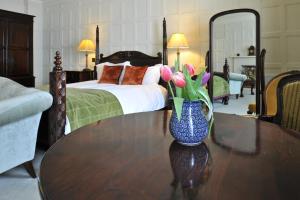 a vase of flowers sitting on a table in a bedroom at The Old Vine in Winchester
