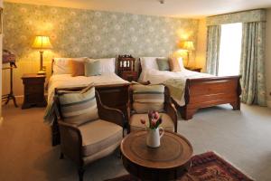 a hotel room with two beds and a table and chairs at The Old Vine in Winchester