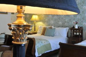 a hotel room with a bed with a lamp and a bed sidx sidx at The Old Vine in Winchester