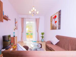 ein Wohnzimmer mit einem Sofa und einem TV in der Unterkunft Seaside Apartments Malta Mellieha1 in Mellieħa