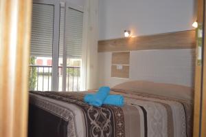 Un dormitorio con una cama con toallas azules. en Hostal Rural Amador, en Puente de Vadillos