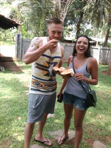 mężczyzna i kobieta jedzący talerz jedzenia w obiekcie Sayo Villa w Negombo