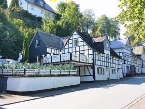 a black and white building with a garden in front of it at Beautiful holiday home near the ski area in Schmallenberg