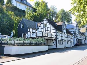 un edificio blanco y negro con un jardín delante de él en Beautiful holiday home near the ski area, en Schmallenberg