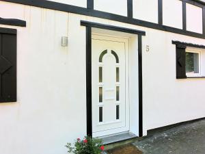 una puerta blanca en el lateral de un edificio en Beautiful holiday home near the ski area en Schmallenberg