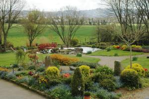un jardín con flores y un estanque en un parque en Chambres d'Hotes Belard, en Plonévez-Porzay 32 fotos más