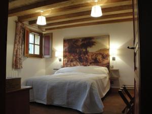 a bedroom with a large bed with a painting on the wall at Superb villa with private heated pool in Revigny-sur-Ornain