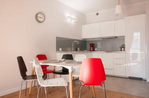 a kitchen with a table and red chairs at Apartament Uniwersytet in Toruń