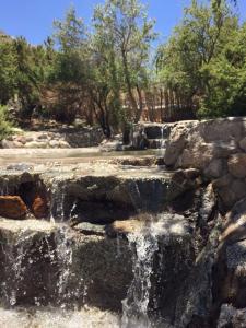 wodospad w parku z kamieniami i drzewami w obiekcie Cabañas Luna de Cuarzo, Cochiguaz w mieście Paihuano