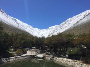 a pool of water in front of a snow covered mountain at Cabañas Luna de Cuarzo, Cochiguaz in Paihuano