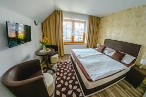 a hotel room with a bed and a chair at Penzion Panda in Turčianske Teplice