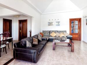 a living room with a black leather couch and a table at Belvilla by OYO Mango II 6 pax in Playa Blanca