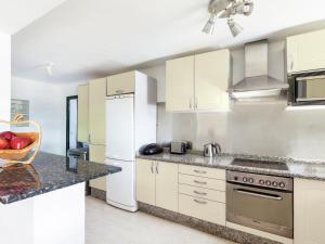 a kitchen with white cabinets and a white refrigerator at Belvilla by OYO Mango II 6 pax in Playa Blanca