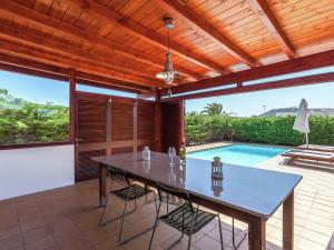 a patio with a table and a swimming pool at Belvilla by OYO Mango II 6 pax in Playa Blanca