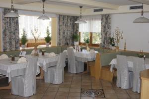 un comedor con mesas y sillas blancas en Hotel Sonnenheim en Bad Kleinkirchheim