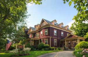 Una grande casa con una bandiera americana davanti di Berry Manor Inn a Rockland