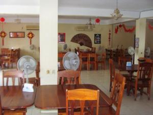 comedor con mesas y sillas de madera en Mirador Hotel, en Corozal