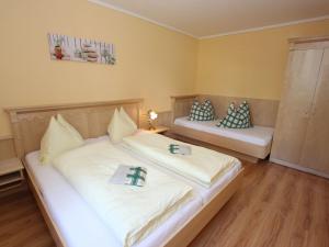 1 Schlafzimmer mit 2 Betten mit weißer Bettwäsche und Kissen in der Unterkunft Apartment close to the ski area in Hüttschlag