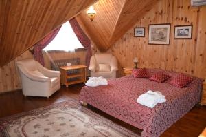 1 dormitorio con 1 cama, 2 sillas y ventana en Chumatskiy Shlyah, en Romankiv