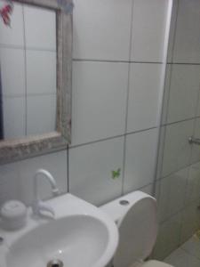 uma casa de banho com um WC, um lavatório e um espelho. em Pousada A Vida é Bela em Águas Belas