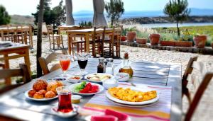 a table with plates of food and drinks on it at Akvaryum Hotel in Bozcaada