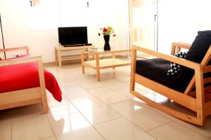Una sala de estar con dos sillas y un televisor. en Photothea Apartments, en Protaras