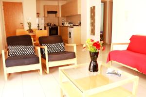 - un salon avec un canapé, des chaises et une table dans l'établissement Photothea Apartments, à Protaras