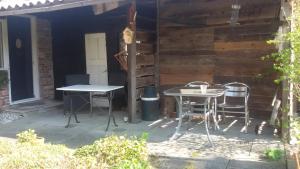 a patio with two chairs and a table in front of a house at B&B Meerland in Oostwold