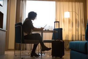 a person sitting at a table with a laptop at Novotel RJ Porto Atlantico in Rio de Janeiro