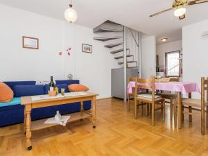 ein Wohnzimmer mit einer blauen Couch und einem Tisch in der Unterkunft Apartment in Šilo near the Sea in Šilo