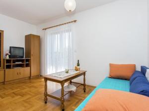 ein Wohnzimmer mit einer blauen Couch und einem Tisch in der Unterkunft Apartment in Šilo near the Sea in Šilo + 32 Fotos