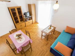 ein Wohnzimmer mit Tisch und Couch in der Unterkunft Apartment in Šilo near the Sea in Šilo