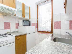 eine weiße Küche mit Spüle und Mikrowelle in der Unterkunft Apartment in Šilo near the Sea in Šilo