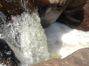 a stream of water coming out of a waterfall at Pousada Chalés da Lua in Munhoz