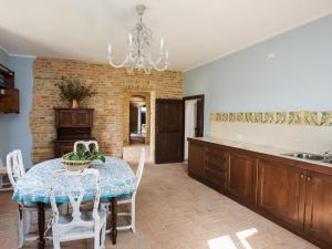 サルソマッジョーレ・テルメにあるQuaint Holiday Home in Tabiano Castello with Private Poolのキッチン(テーブル、椅子、シャンデリア付)