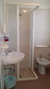 ein Badezimmer mit Waschbecken und Toilette in der Unterkunft Hotel La Falena in Cervia
