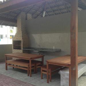 a patio with picnic tables and a brick oven at Porto Real Suítes in Mangaratiba