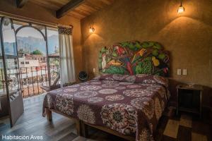- une chambre avec un lit orné d'une peinture murale dans l'établissement Flor de Cera, à Tepoztlán