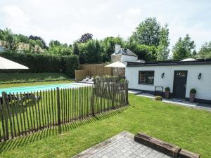 a backyard with a fence and a pool at Modern Mansion in Hasti re par Del with Pool in Hastière-par-delà