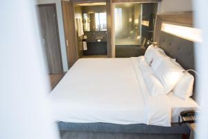 a bedroom with a large bed with white sheets and pillows at Novotel RJ Porto Atlantico in Rio de Janeiro