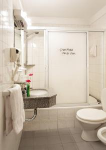 a white bathroom with a toilet and a sink at Gran Hotel De La Paix in Buenos Aires