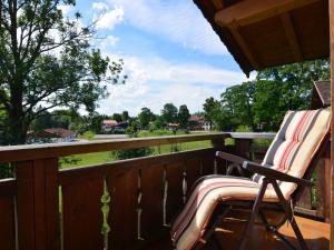 a rocking chair on a deck with a view of a yard at Ferienwohnung in Bad Bayersoien in Bad Bayersoien