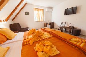 una camera da letto con un letto con lenzuola e asciugamani arancioni di Guest House Rustico a Korenica