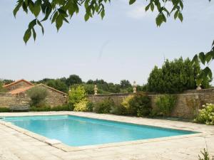 a swimming pool in a yard next to a brick wall at Beautiful holiday home with private pool in Boussageau
