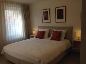 a bedroom with a large white bed with two lamps at Comfort Aan Zee Guestrooms in Ostend